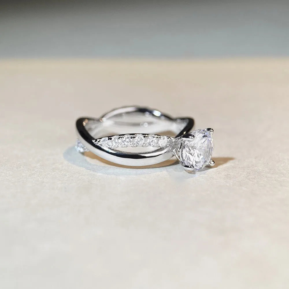 Geometric twisted silver-coloured band moissanite ring with a 1 carat stone in a four-claw setting.