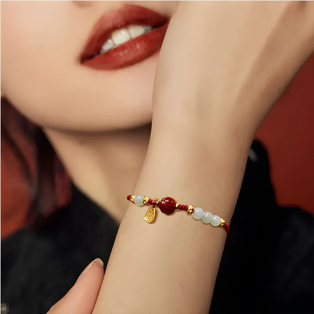 Close-up of a women's bracelet with Hetian jade and red cinnabar beads on an adjustable 925 silver chain.