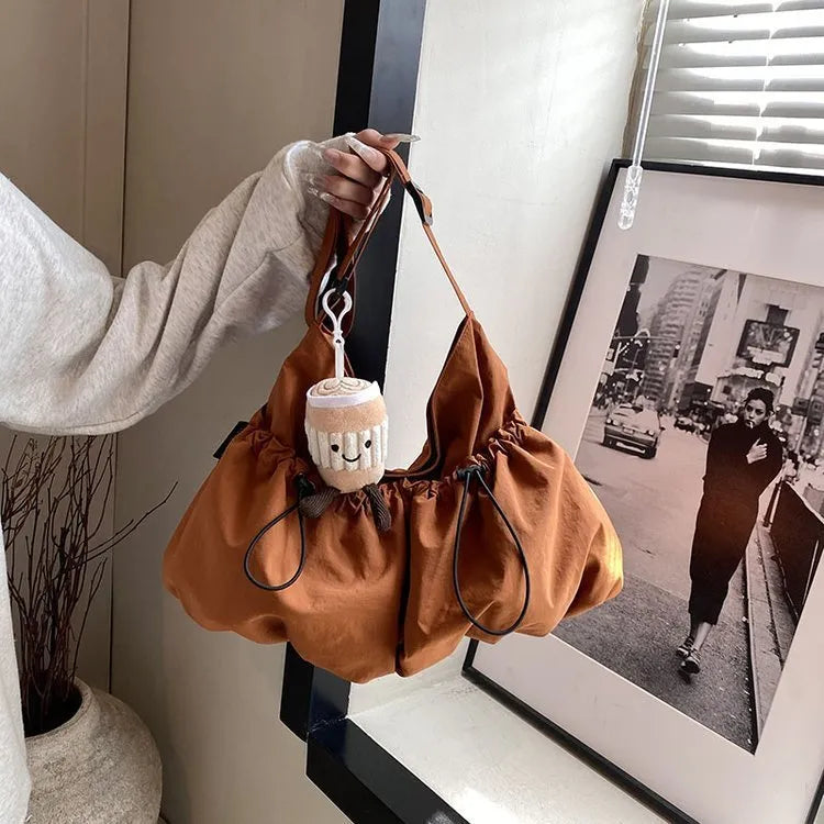 Soft green pleated polyester crossbody bag with a split pocket, shown folded and open with phone pocket visible.