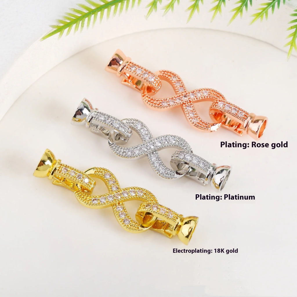 Small gold-colour metal jewellery clasp with a white pearl detail on the buckle
