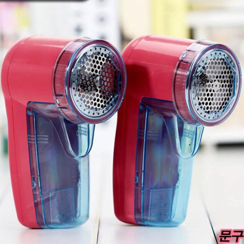Compact white portable electric lint remover for clothing on a grey background.