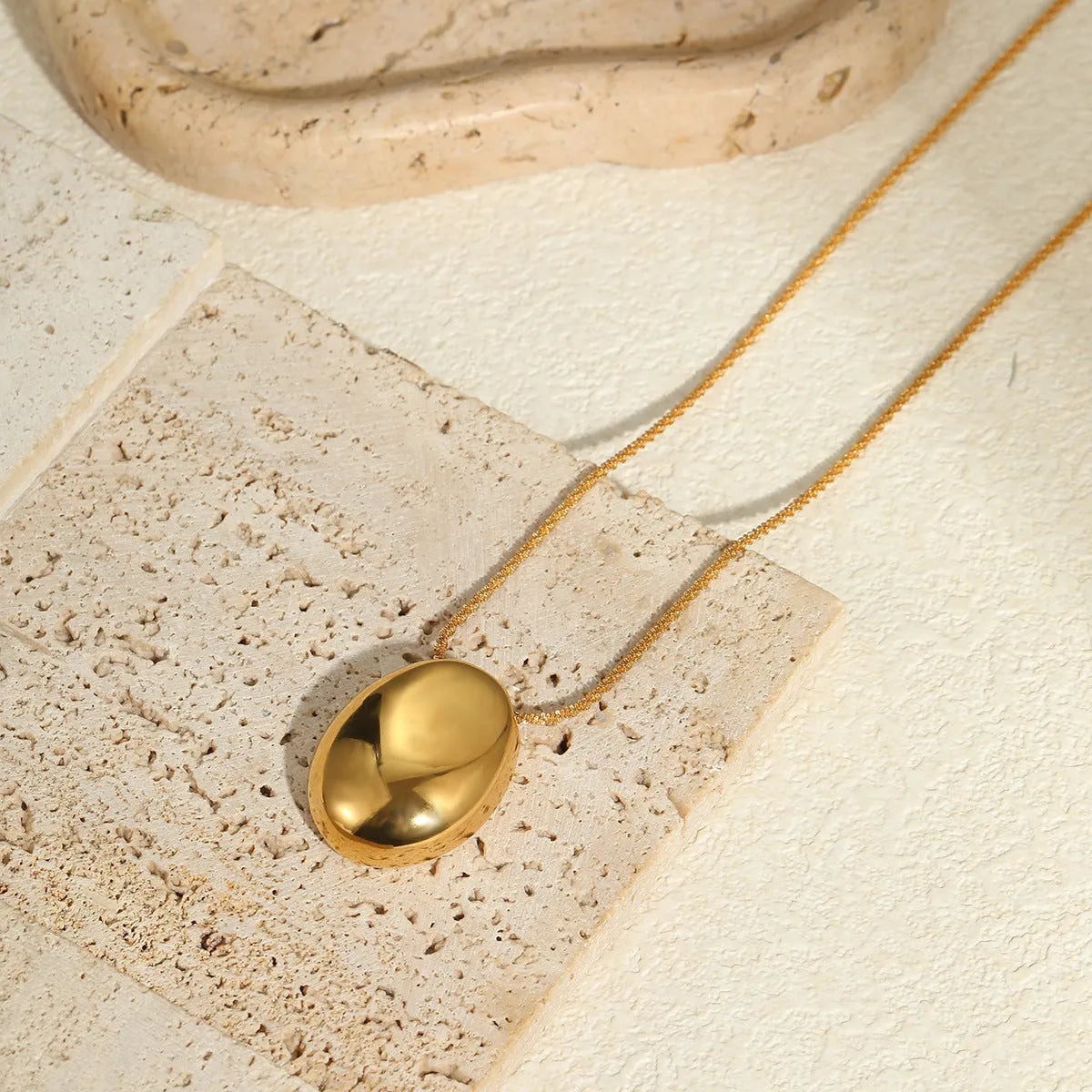 Gold-plated geometric pendant long necklace with adjustable chain on dark background