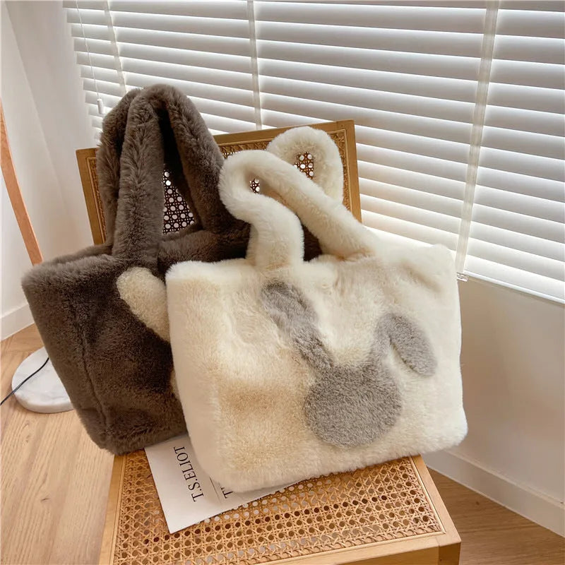 Soft plush tote bag with cartoon rabbit ears on the front in a solid colour.