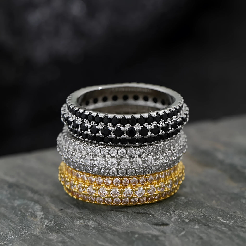 A geometric unisex ring with a triangular zircon stone inlay, shown in white gold, yellow gold and white and black plating finishes.