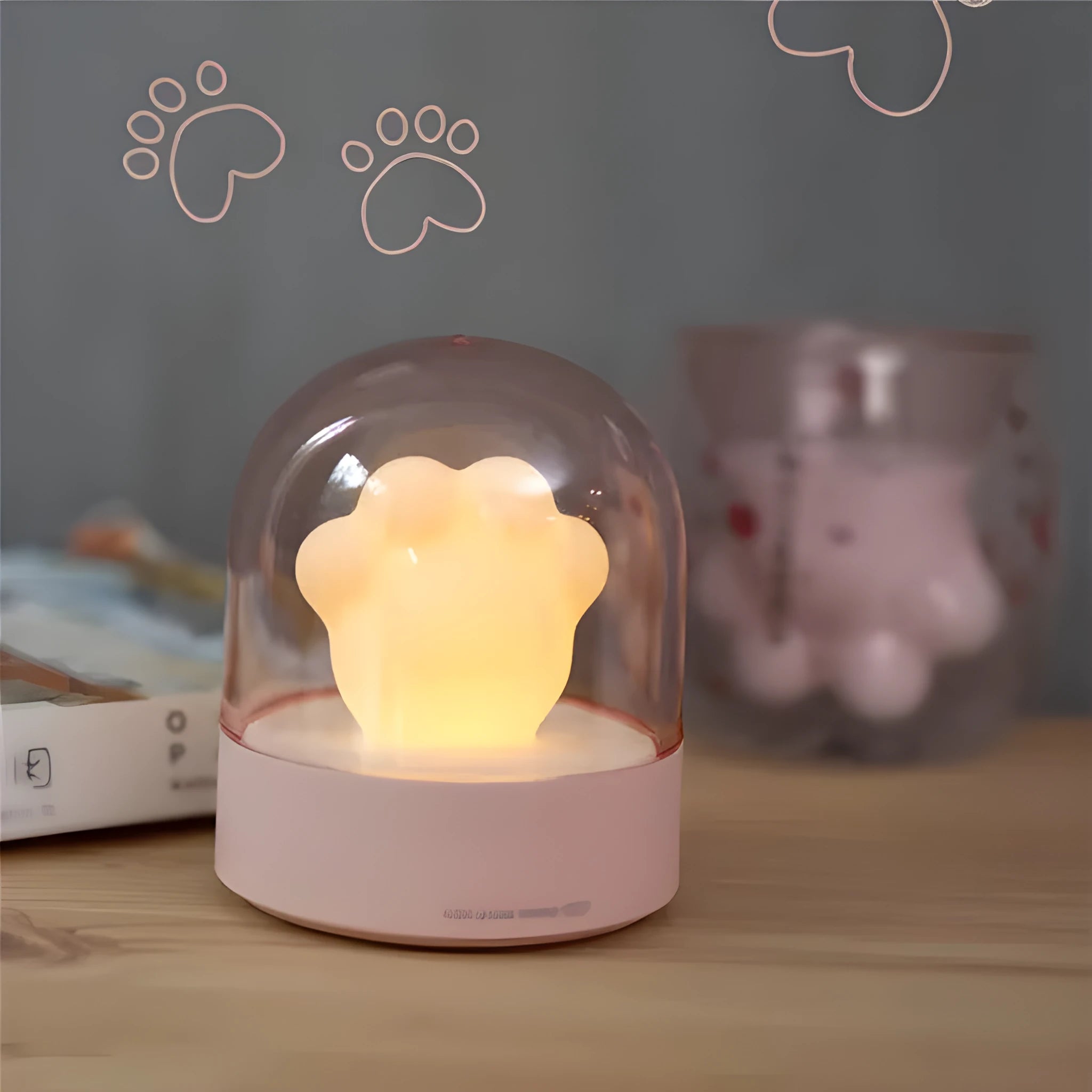 Grey and pink cat paw shaped USB rechargeable night light with music box function on desktop