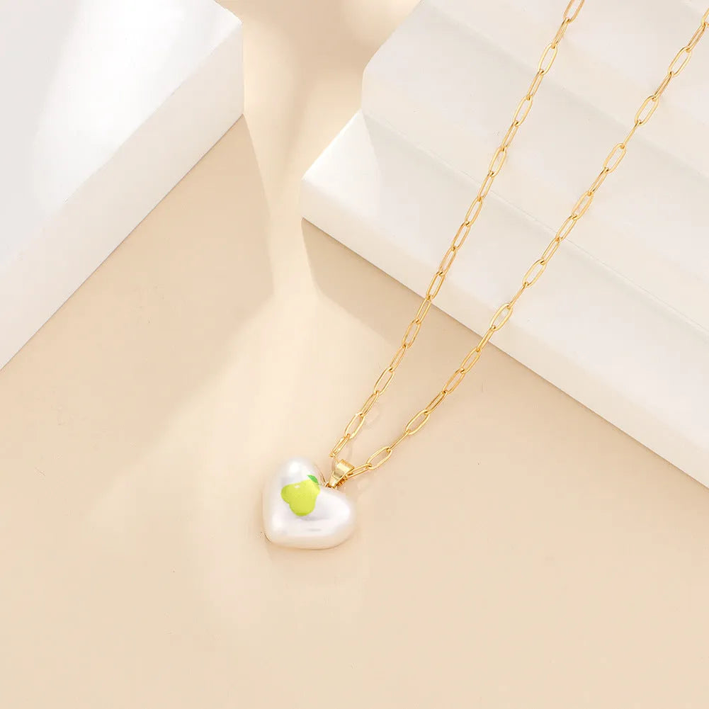 Geometric heart-shaped necklace with a choice of strawberry, pineapple, apple, pear or cherry pendant on an adjustable chain.