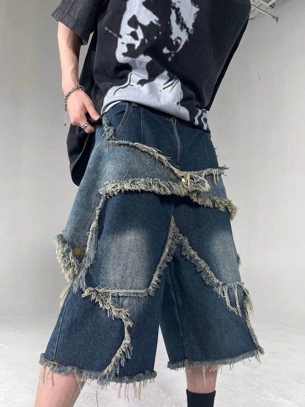 Blue denim shorts with frayed hem and five-pointed star detail, loose fit silhouette