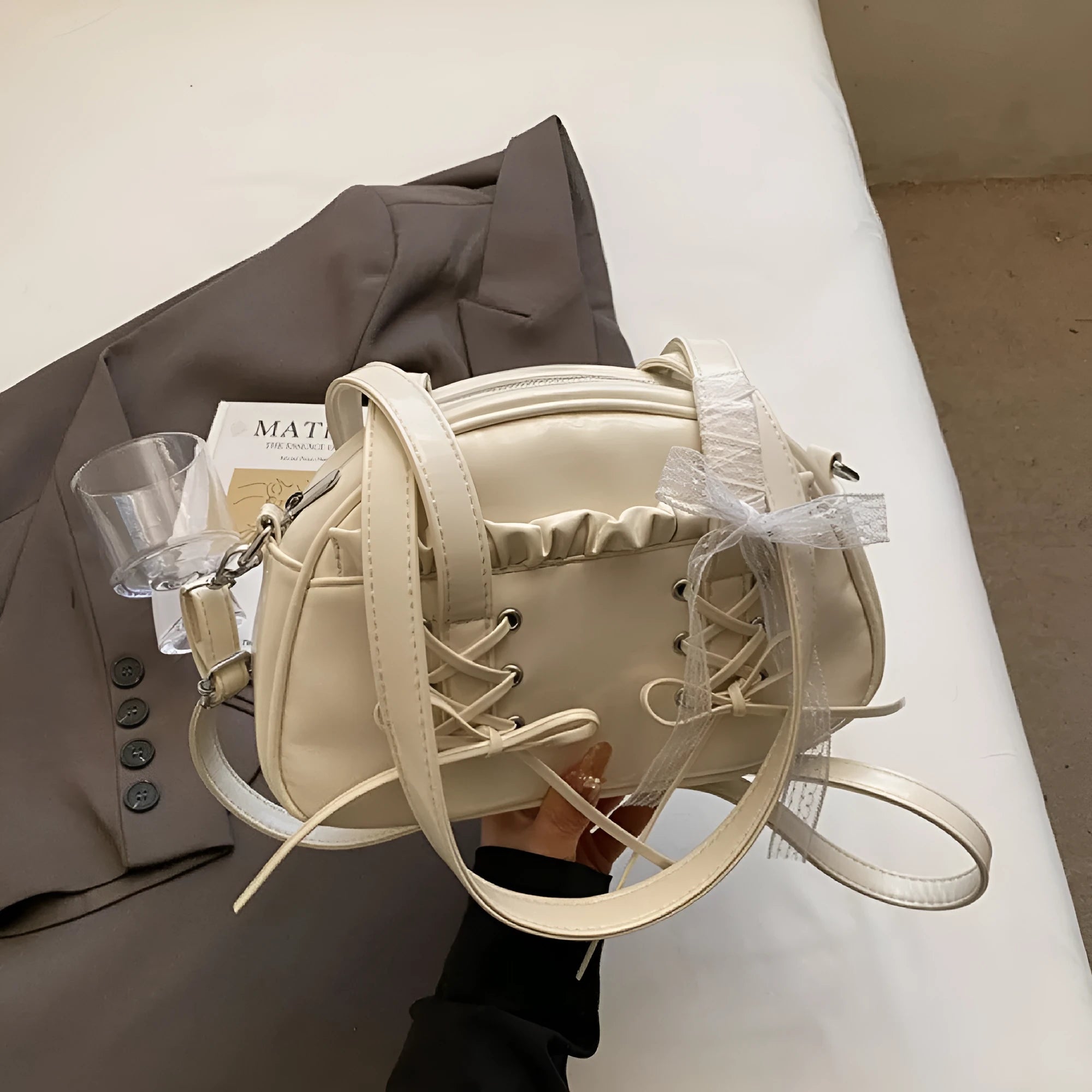 Women's bandage bow handbag in milky white colour with adjustable bow detail and internal mobile phone compartment