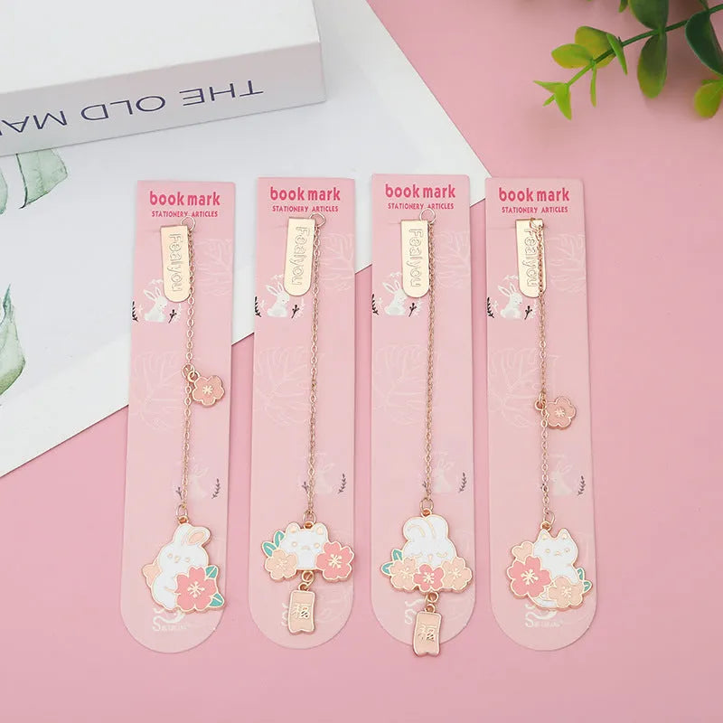 Small metal pendant bookmark with cartoon Sakura cat or cherry blossom rabbit illustration.