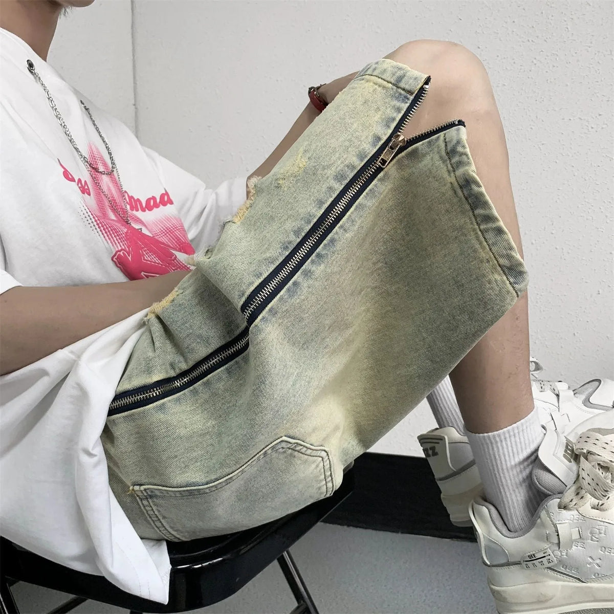 Retro blue men's denim shorts with yellow mud wash and ripped details, loose fit.
