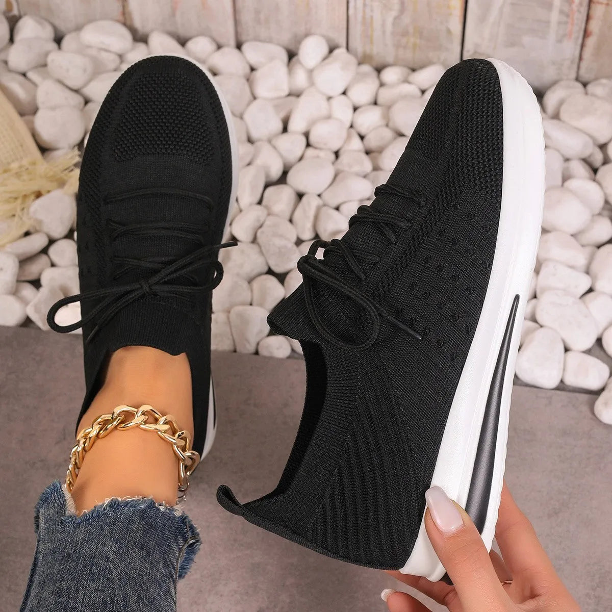 Women's low-top lace-up sneakers in red, black, or blue with a fly-knit texture and round toe.