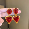 A pair of silver needle pleated oval love heart stud earrings in alloy metal, showing the textured surface and heart shape.