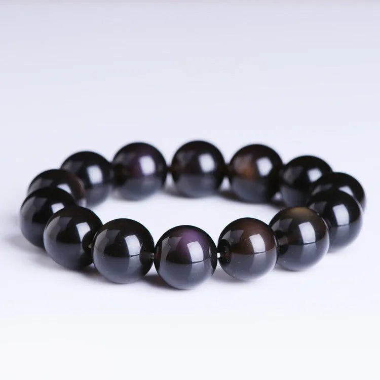 Polished crystal Pi Xiu bracelet with icy obsidian stone on wrist, showing geometric ethnic style.