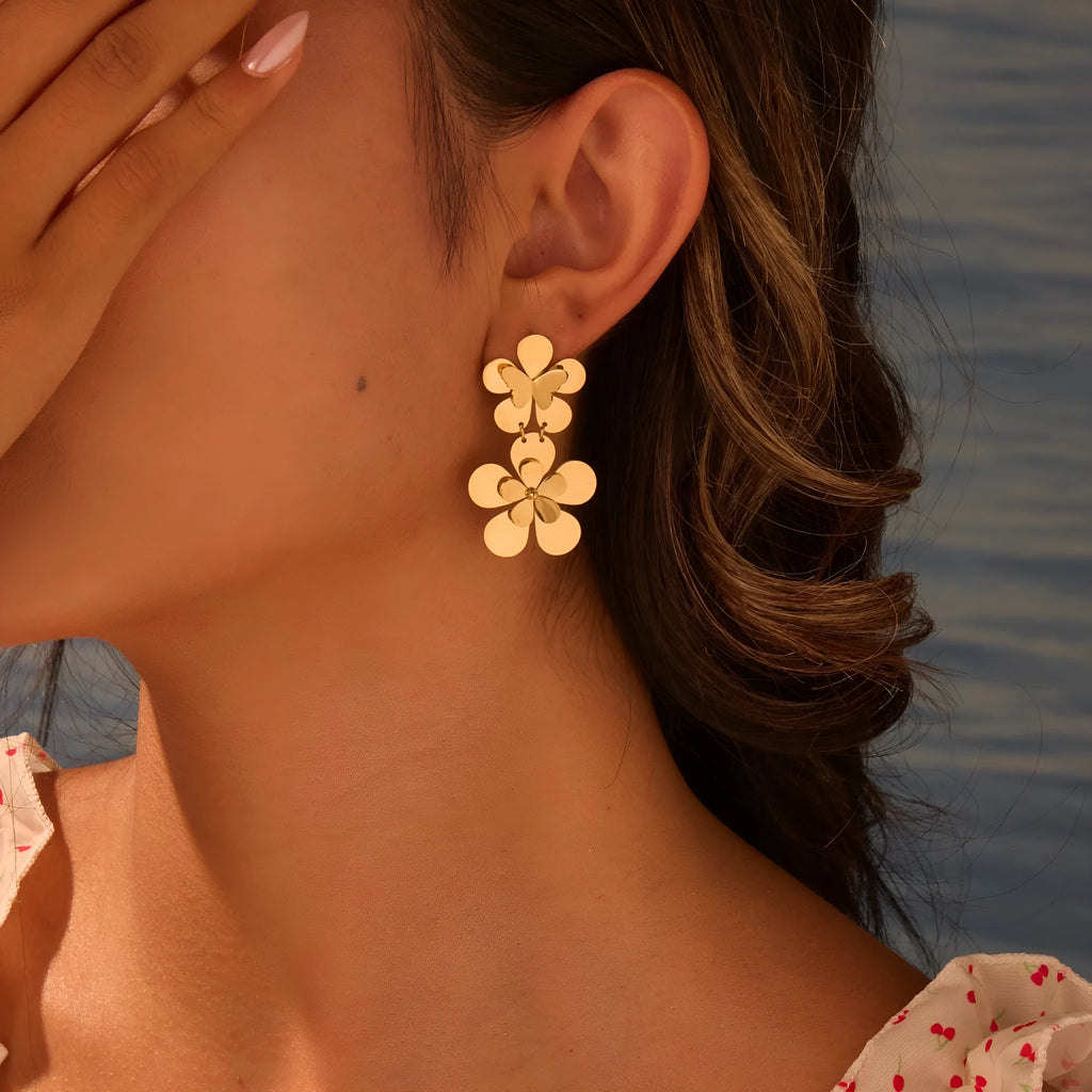 Gold coloured flower butterfly earrings with geometric and zodiac details on stainless steel.