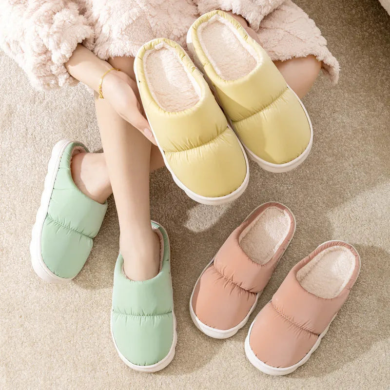 A pair of down cotton slippers with a thick rubber sole and artificial leather upper in a selected colour.