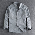 Man wearing a loose-fit grey long sleeve cardigan-style shirt, showcasing its relaxed silhouette and polyester material.