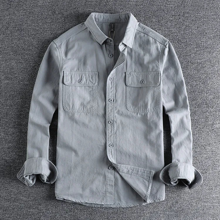 Man wearing a loose-fit grey long sleeve cardigan-style shirt, showcasing its relaxed silhouette and polyester material.