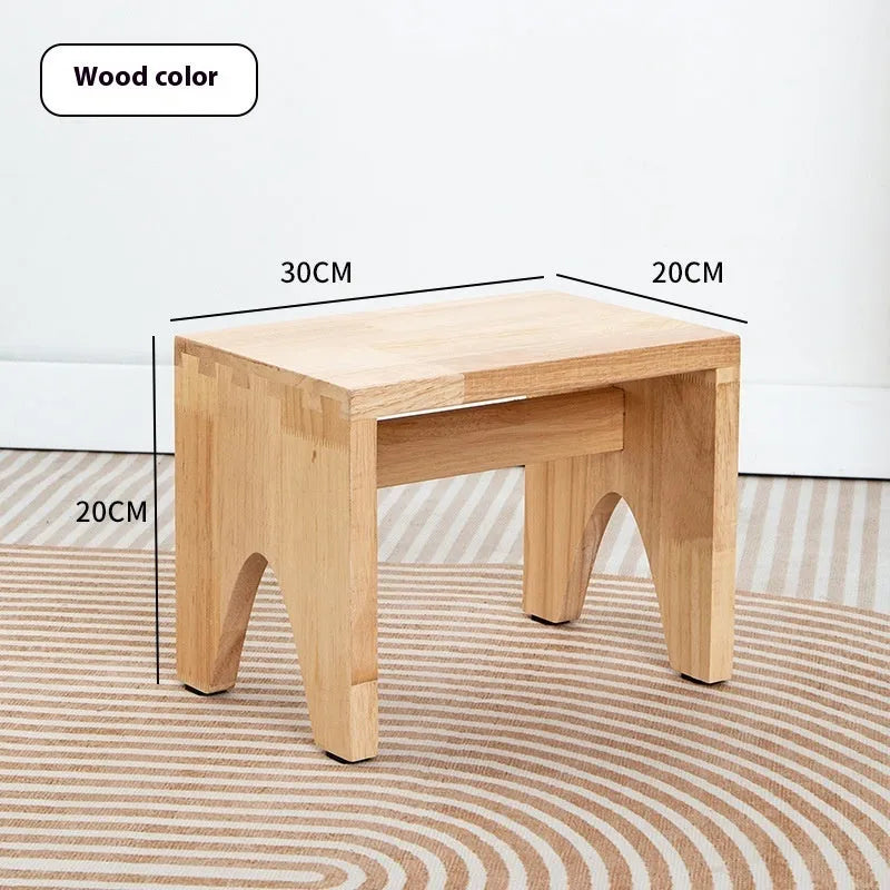 Distressed solid wood changing stool with bracket structure in a rustic finish.