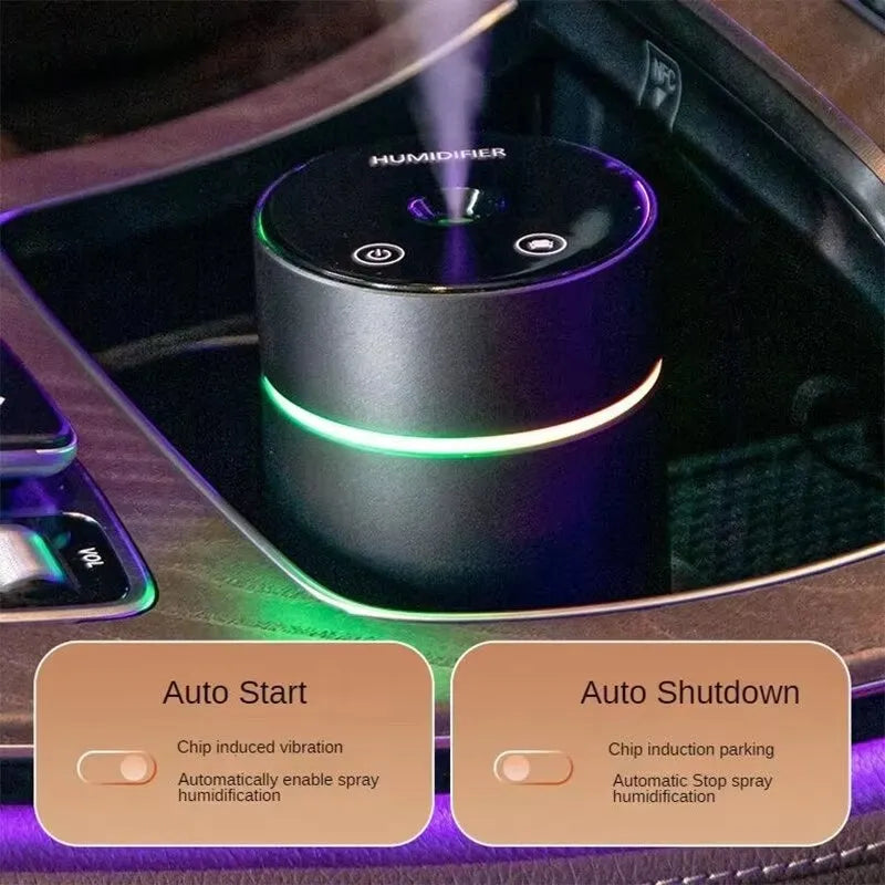 Compact black aluminium car humidifier and essential oil diffuser with USB cable on a desk.