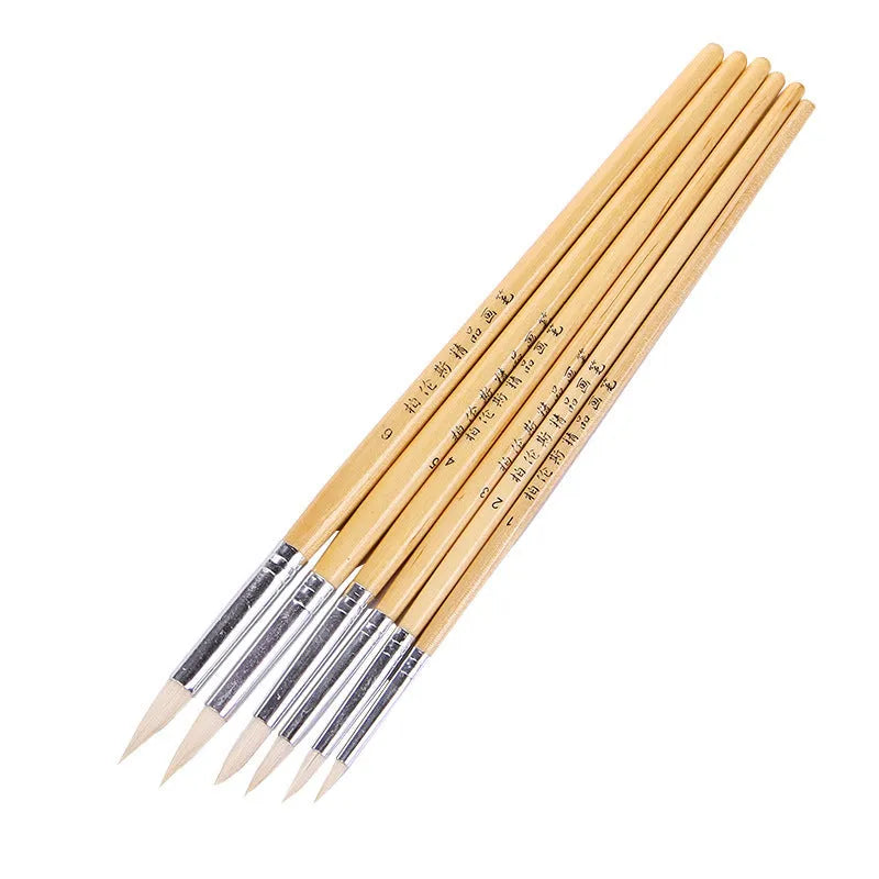 Six wooden brush pens with pointed wool felt tips arranged together as an artist set