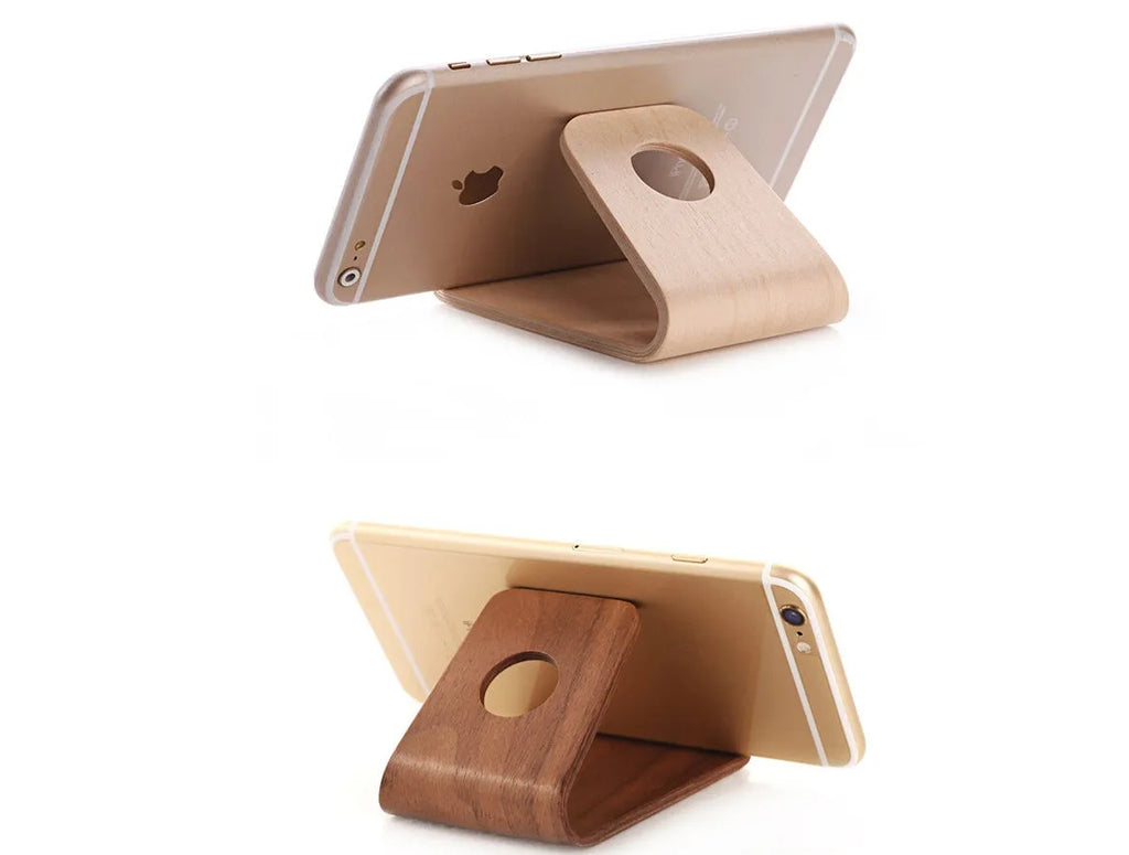 Wooden phone stand in walnut brown and white maple holding an iPhone upright on a desk.