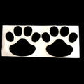 Close-up of a black PVC car sticker with dog footprints and a hand-shaped brush texture on a car bumper.