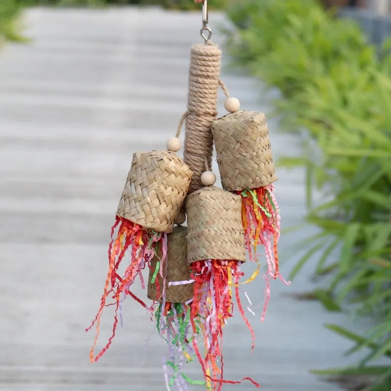 Parrot toy with wood pieces, sisal rope and colourful shredded paper strips hanging for bird enrichment