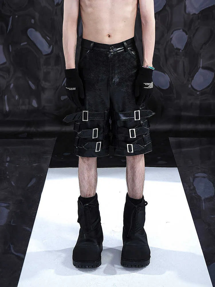 Men's black PU leather cropped shorts on a hanger, showing low waist and casual fit.