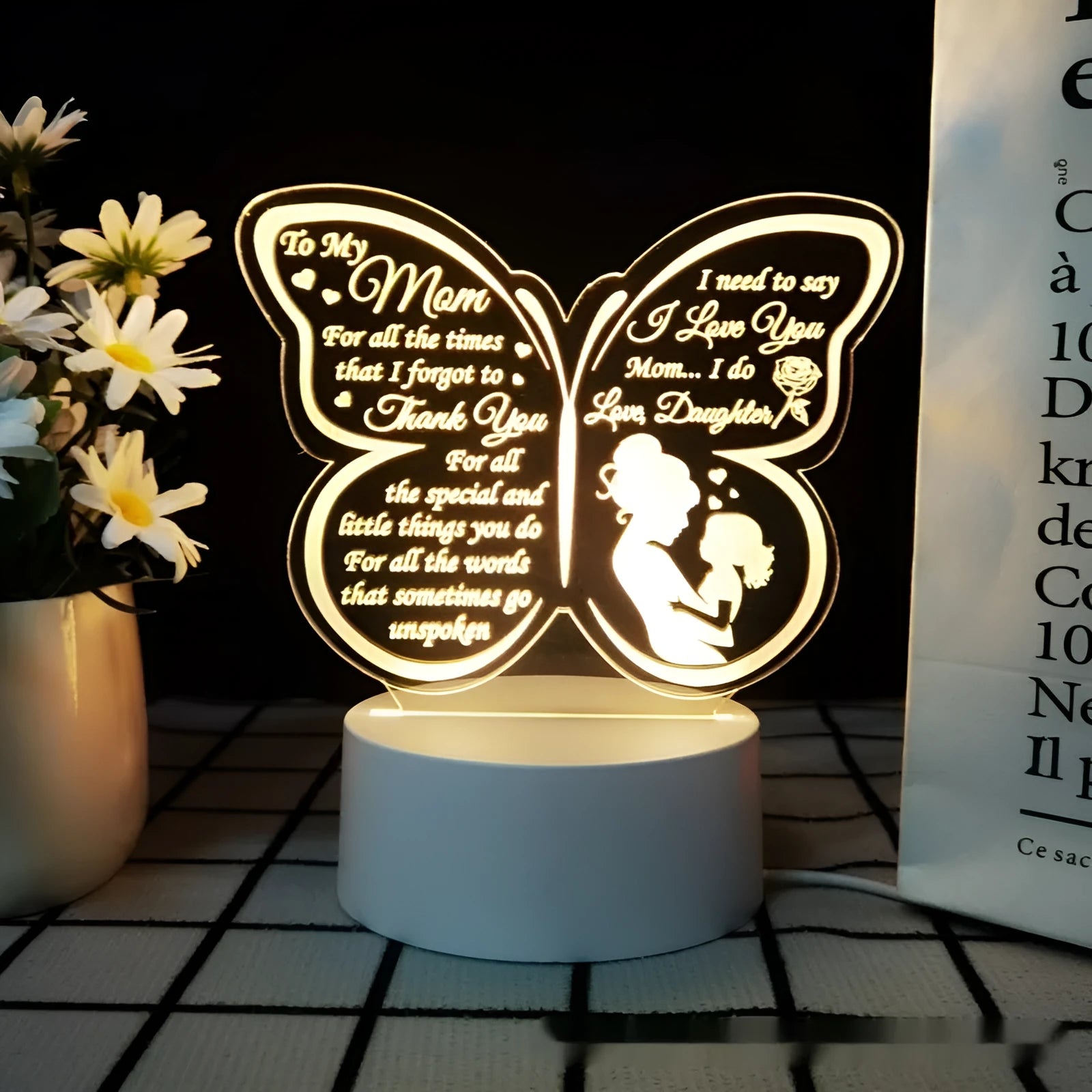 Clear acrylic heart-shaped table lamp with warm white light on a table.