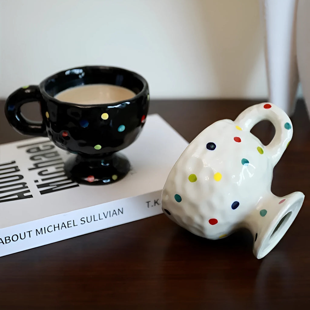 Hand-pinched irregular shaped ceramic mug in a solid colour, shown on a surface.
