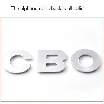3D metal car letter sticker in zinc alloy, shown in black and silver finishes, approx. 2.5 cm in size.