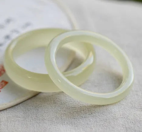 Round bar jade bracelet with geometric winding silk jade design, shown in a listed inner diameter size