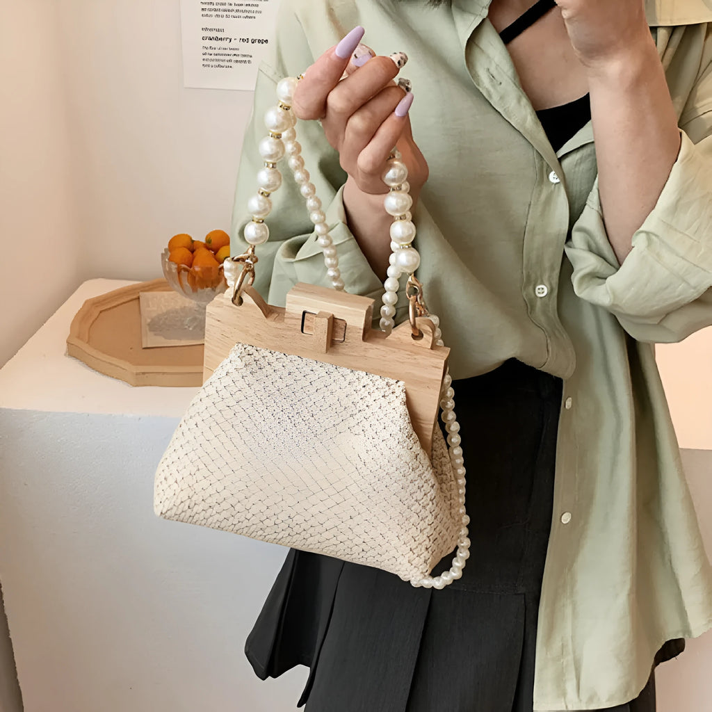 Women's woven straw shoulder bag with pearl chain detail in beige, showing horizontal square shape and single strap.