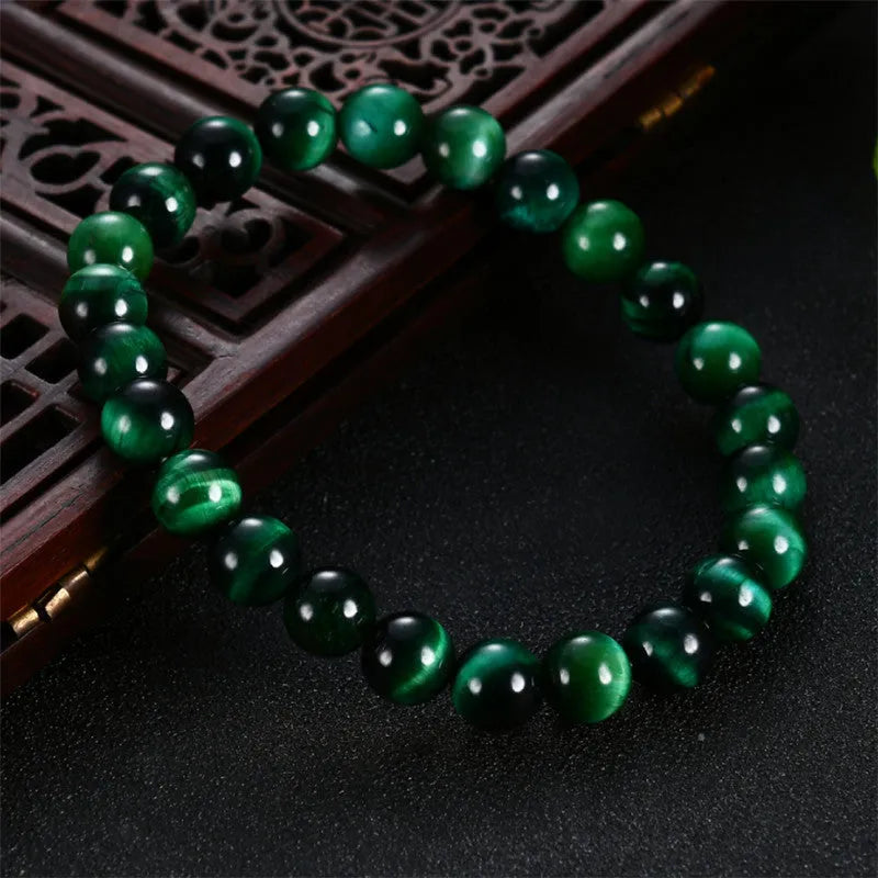 A polished green tiger eye stone bracelet with geometric beads, shown in various size options.