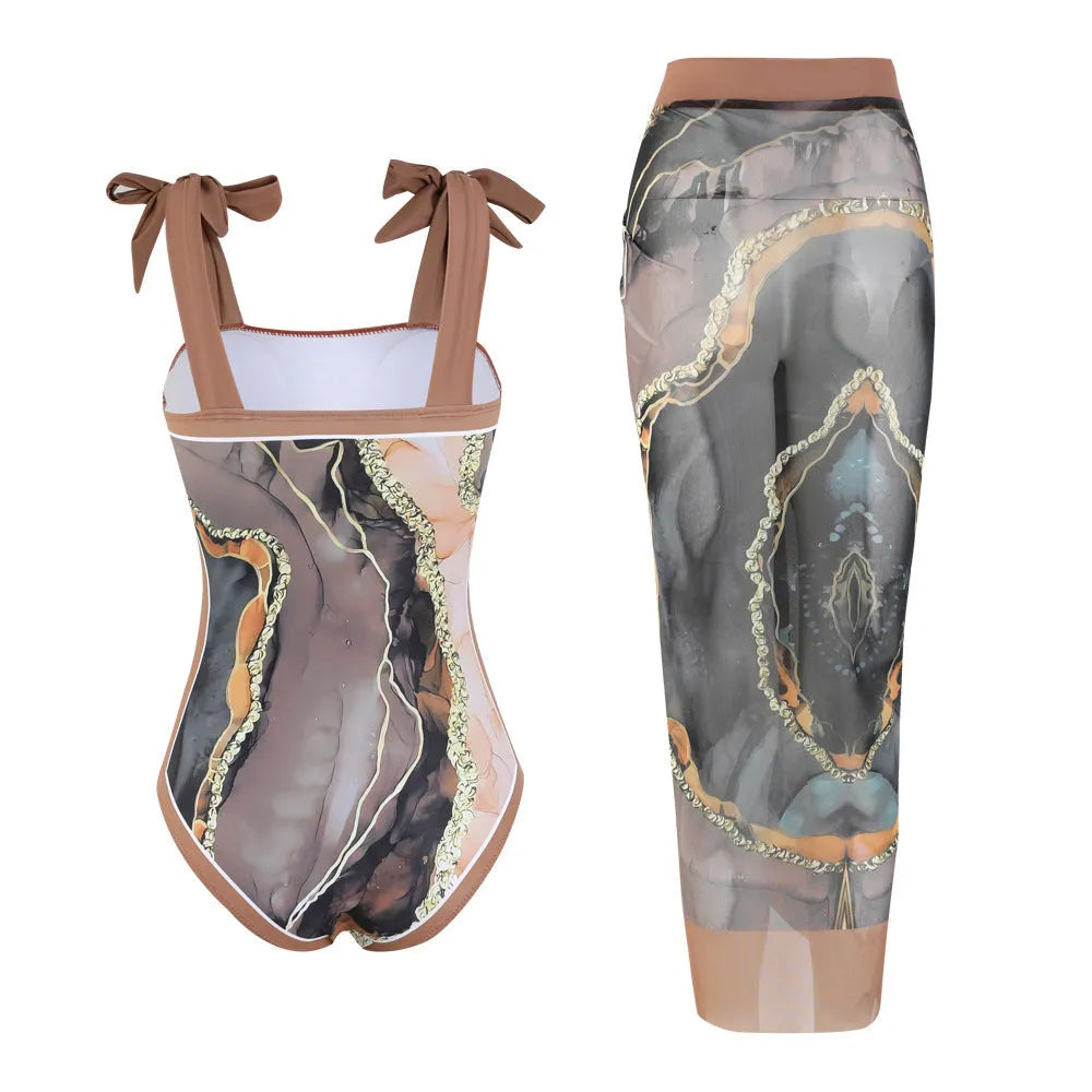 Floral print one-piece swimsuit with mesh tube top and detached skirt shown in brown.