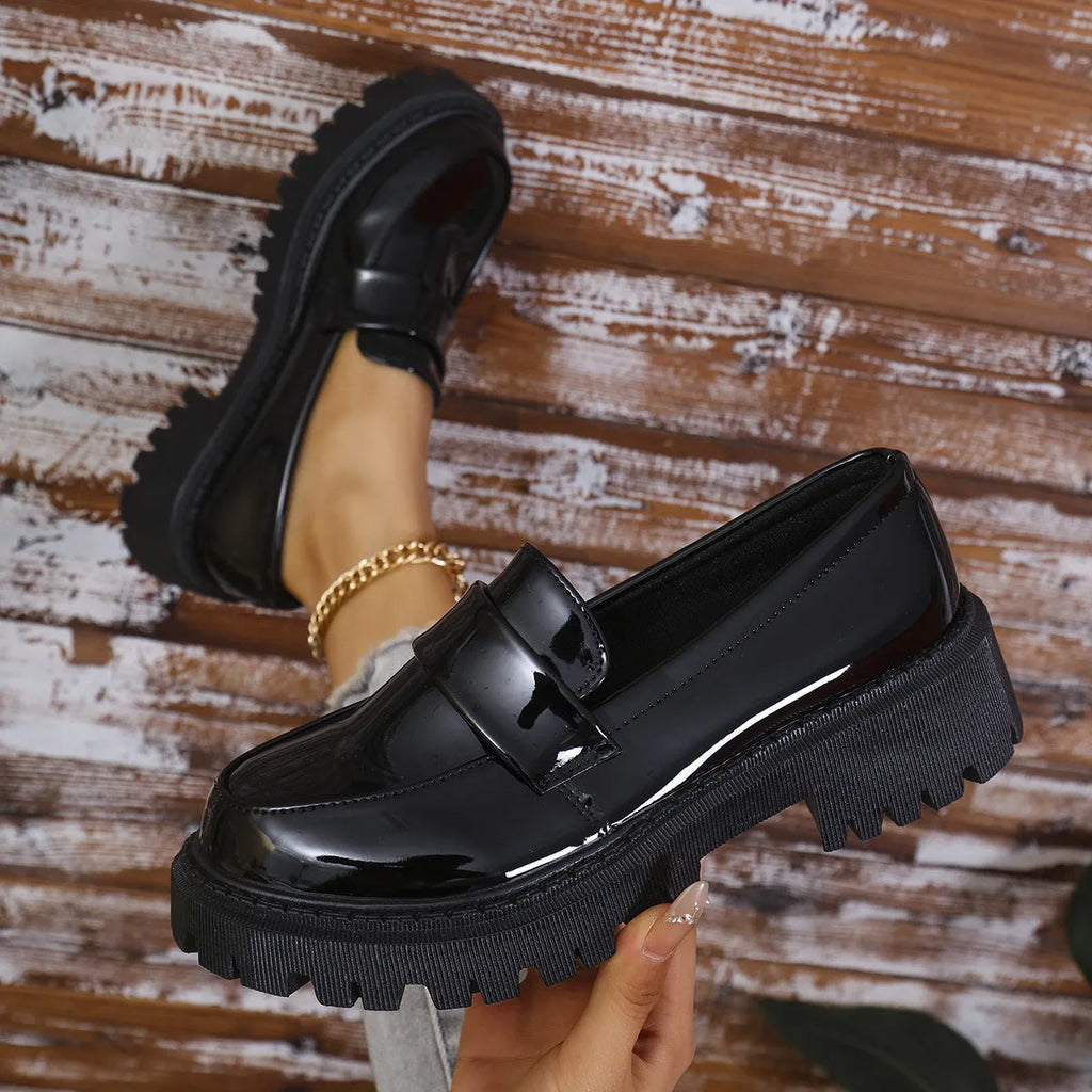 Women's black slip-on loafers with a chunky platform heel and rubber sole.