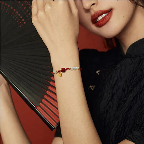 Close-up of a women's bracelet with Hetian jade and red cinnabar beads on an adjustable 925 silver chain.