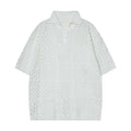 Man's black short-sleeved polo shirt with a hollow-knit texture and a loose, cardigan-style fit.