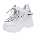 White women's low-top mesh sneakers with a black cross strap and a thick rubber platform sole.