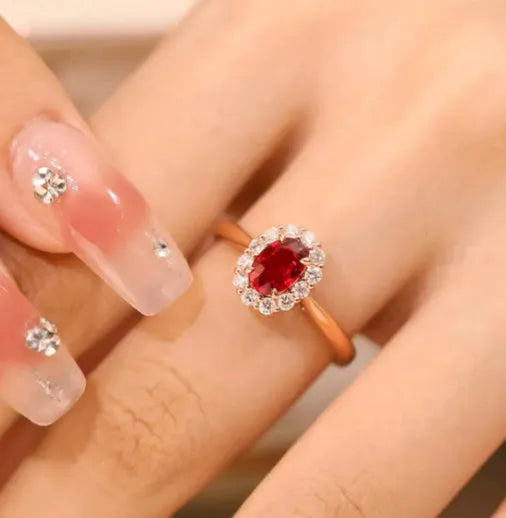 Silver ladies ring with blood ruby gemstone, gold pigeon inlay, and floral pattern design.