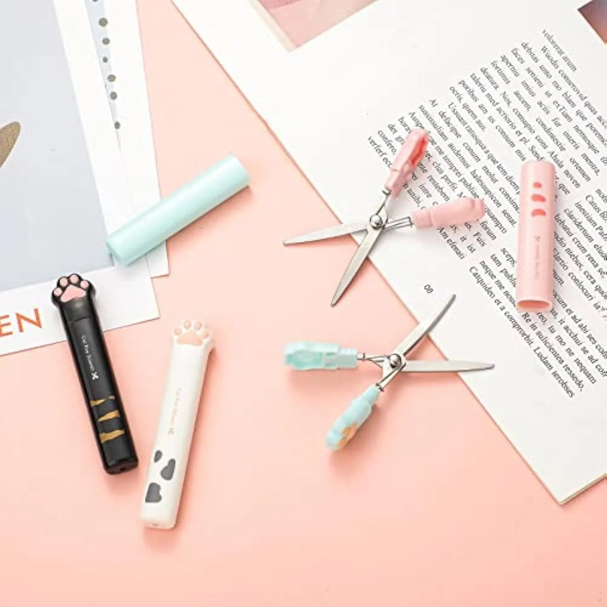 Cat paw mini folding scissors in four colours: pink, white, black, and blue, showing closed and open positions.