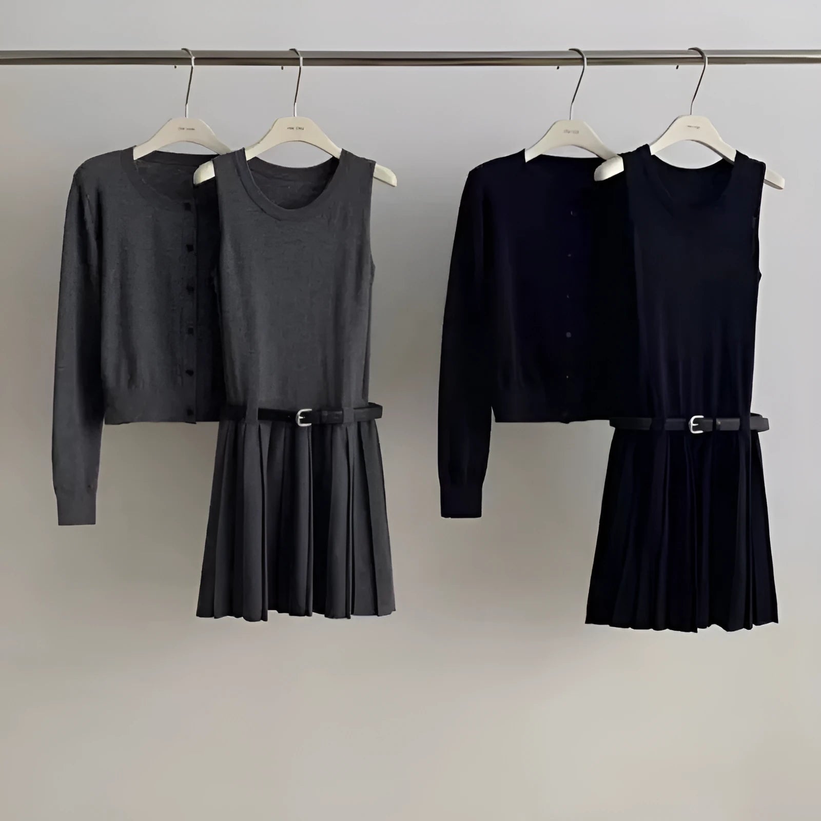 Women's grey knitted cardigan and pleated vest skirt two-piece set with a belt.
