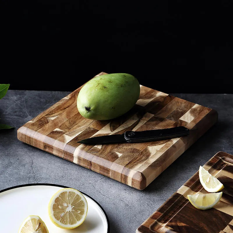 Brown acacia solid wood parquet cutting board with 3cm thickness on a kitchen counter.