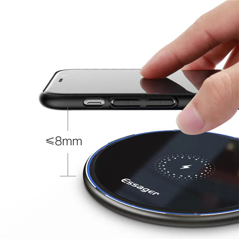 Black or white aluminium alloy wireless charging pad with LED status light on desk.