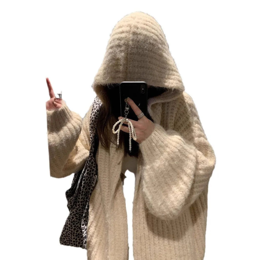 A woman wearing a thick, loose-fit hooded cardigan sweater in a milky white colour.