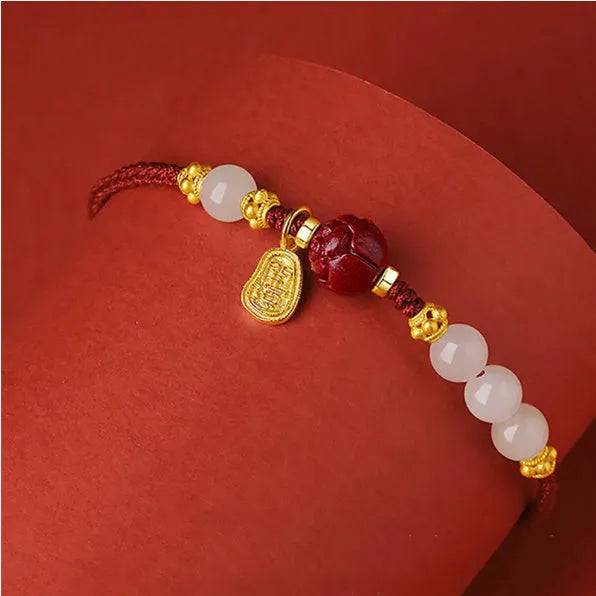 Close-up of a women's bracelet with Hetian jade and red cinnabar beads on an adjustable 925 silver chain.