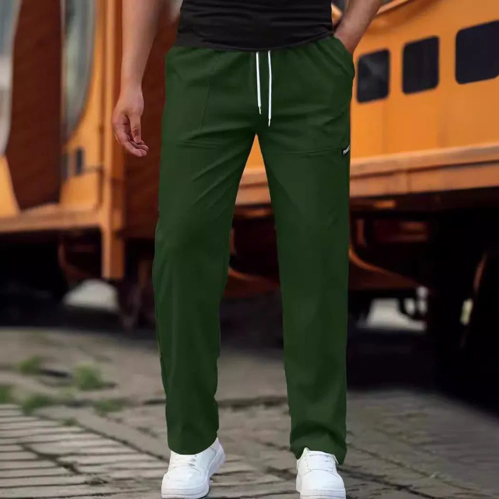Men's light grey tapered slim-fit trousers with an elastic waistband on a hanger.