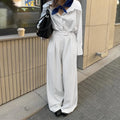 White striped wide-leg women's trousers with front zip fastening on hanger