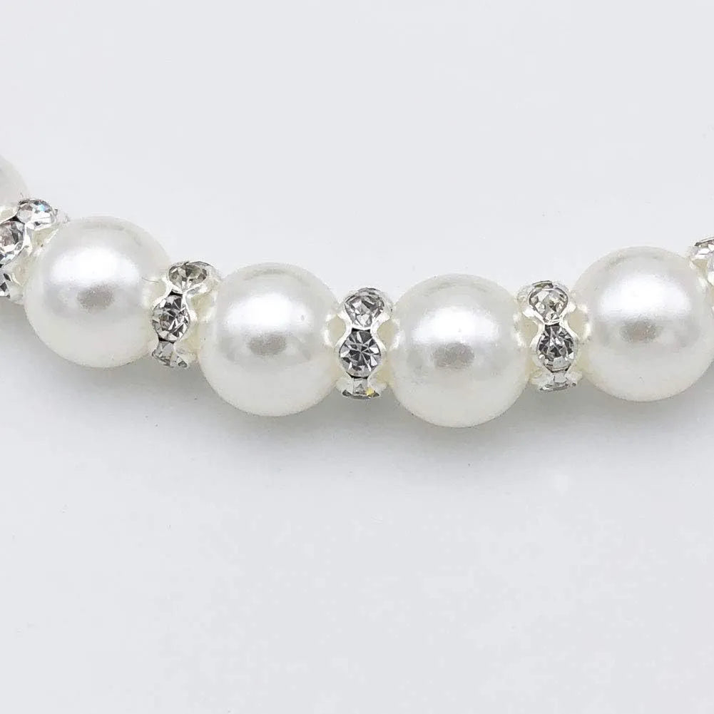 Small dog wearing adjustable pearl and rhinestone necklace with ribbon bow in pink colour