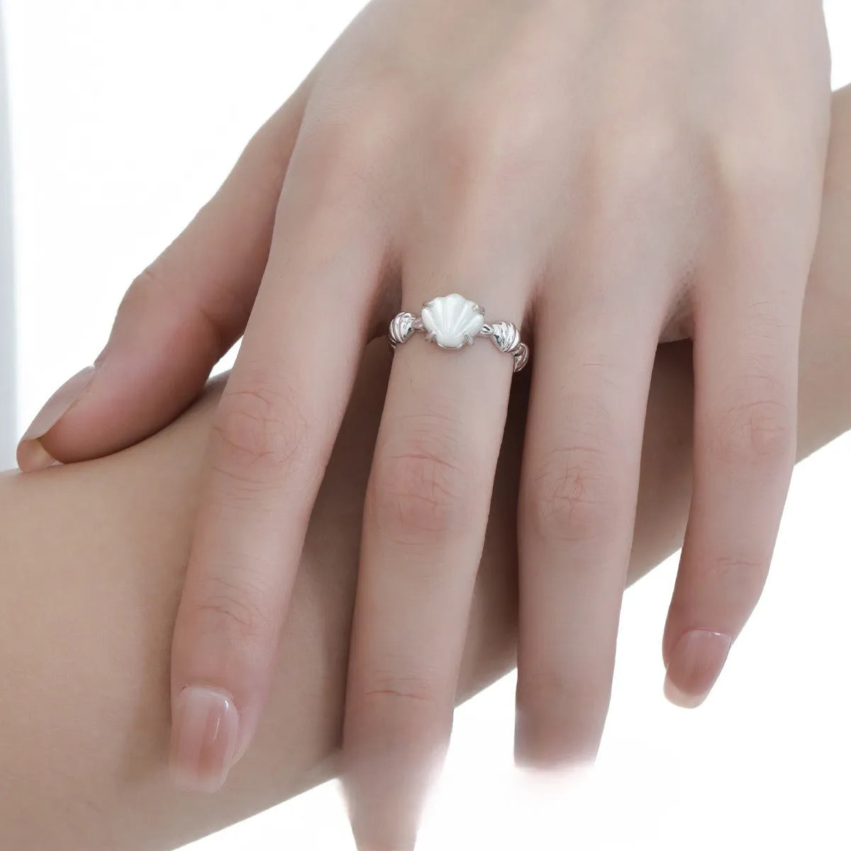 Adjustable silver women's ring with shell design in shell white or tiger eye finish.